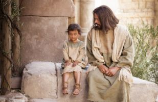Jesus is sitting with a young boy next to him.