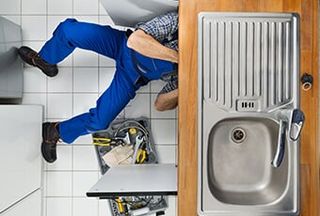 Plumber Examining Kitchen Sink — Plumbing Repair in Tucson, AZ